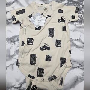 Kate Quinn Baby Onesie with Camera Print